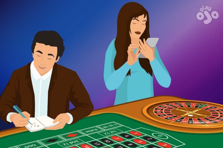 A boy and a girl sit at a roulette table, each intently scribbling on a piece of paper