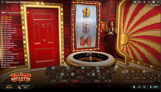 Tela do Red Door Roulette exibindo a roleta ao vivo, a ic&ocirc;nica porta vermelha do jogo, apresentadora em p&eacute; no est&uacute;dio tem&aacute;tico e n&uacute;meros com multiplicadores vis&iacute;veis na mesa. 